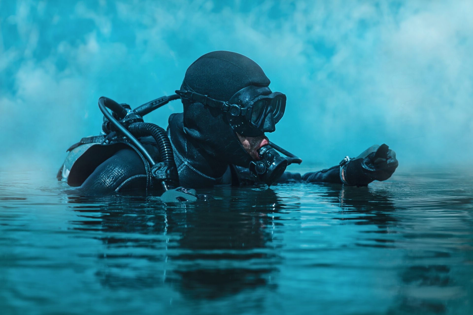 Navy SEAL frogman with complete diving gear and weapons in the water deploying military drones