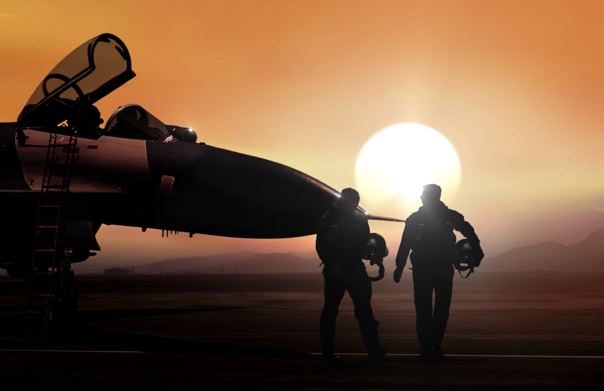 Silhouettes of two pilots walking near a fighter jet with its canopy open, against a large setting sun and an orange sky.