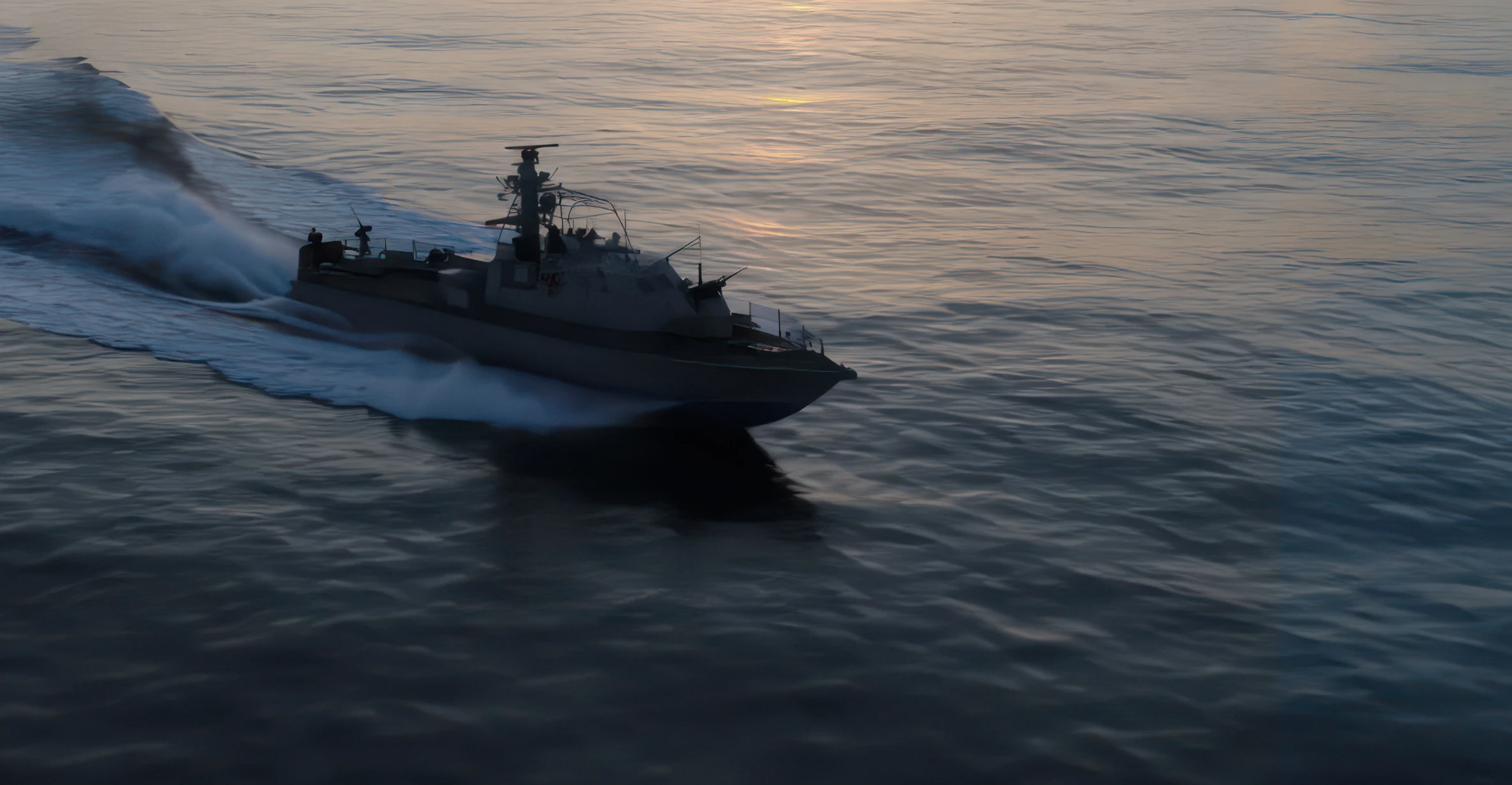 Military patrol boat speeding across calm sea water during sunset with military drones on board