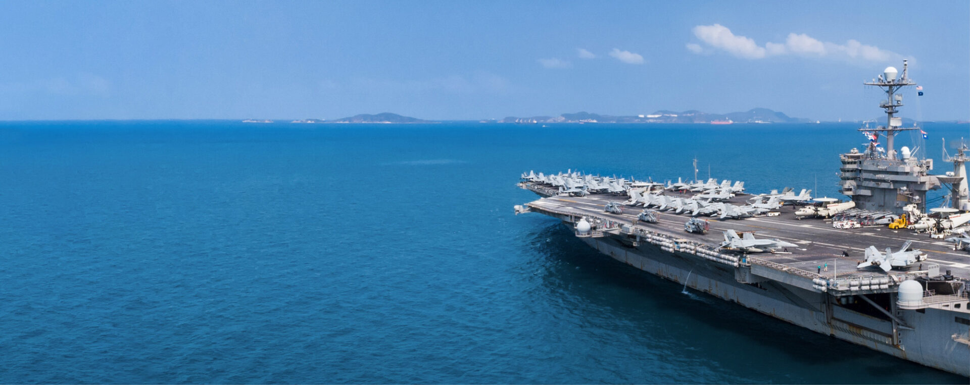Aircraft Carrier In the Sea with military drones, surveillance drones, and tethered drone on board